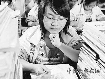 江西吉水中学高三学生饶龙珍在“书堆”中复习功课。宋振平摄(新华社发)